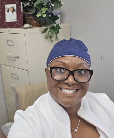 Dr. Drain in a surgical cap and white coat in her office